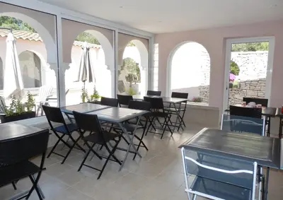 a dining room with tables and chairs and windows at Domaine De Foresta in Bonifacio