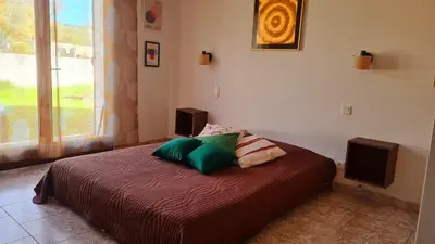 a bedroom with a bed with two pillows on it at Villa à quelques pas de la plage in Santa-Lucia-di-Moriani