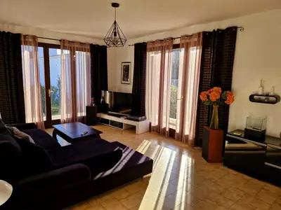 a living room with a couch and a tv at Villa à quelques pas de la plage in Santa-Lucia-di-Moriani