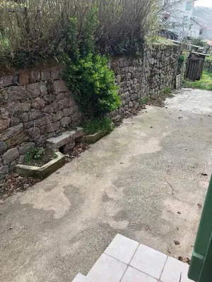 a stone wall with a bench next to a sidewalk at Entre montagne et mer in Bastelica
