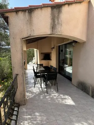 a patio with a table and chairs on it at Altagna in Olmeto