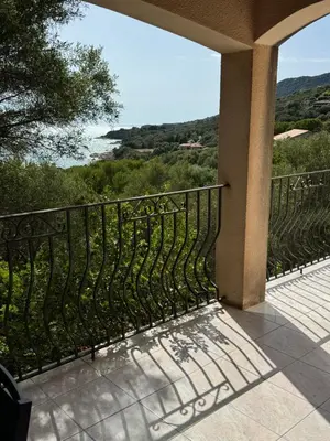 a balcony with a iron fence and a view of the water at Altagna in Olmeto