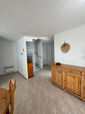 a living room with a table and a wooden cabinet at Altagna in Olmeto