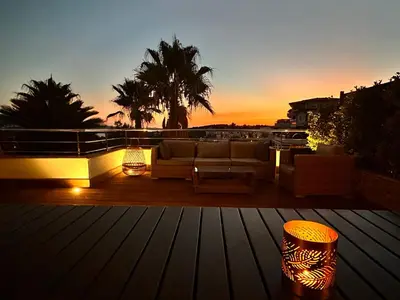 a couch on a deck with a sunset in the background at Le Deck Porticcio in Grosseto-Prugna