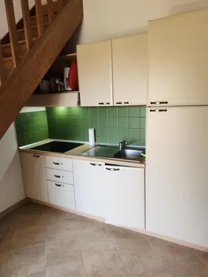a kitchen with white cabinets and a sink at linguizzetta , les marines de bravone in Linguizzetta