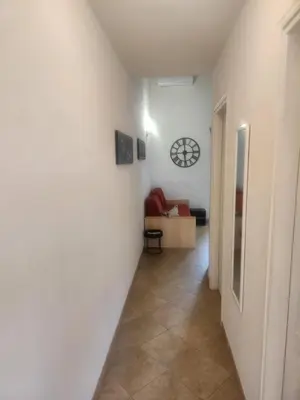 a hallway with a clock on a white wall at linguizzetta , les marines de bravone in Linguizzetta