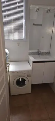 a white kitchen with a washing machine and a sink at jolie appartement pour 4 personnes à propriano in Propriano