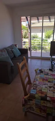 a living room with a couch and a chair and a table at jolie appartement pour 4 personnes à propriano in Propriano