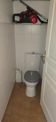 a bathroom with a toilet with a red object above it at jolie appartement pour 4 personnes à propriano in Propriano