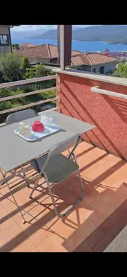a white table and chairs on a balcony with a view at jolie appartement pour 4 personnes à propriano in Propriano