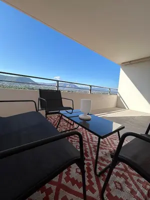 a balcony with two chairs and a table with a laptop on it at Cœur Ajaccio calme plage nature in Ajaccio