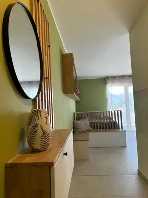 a room with a mirror and a table with a vase at Cœur Ajaccio calme plage nature in Ajaccio