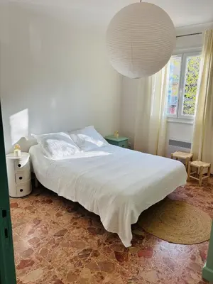 a bedroom with a large bed with a white bedspread at Appartement au cœur de Cargèse in Cargèse