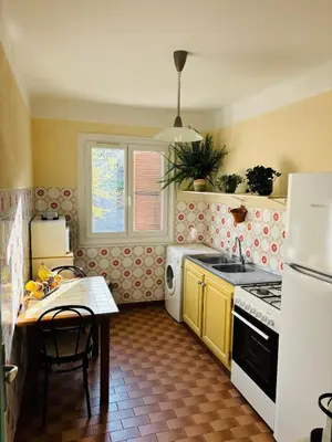 a kitchen with yellow cabinets and a white stove top oven at Appartement au cœur de Cargèse in Cargèse