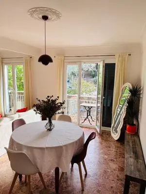 a living room with a table and chairs and a bedroom at Appartement au cœur de Cargèse in Cargèse