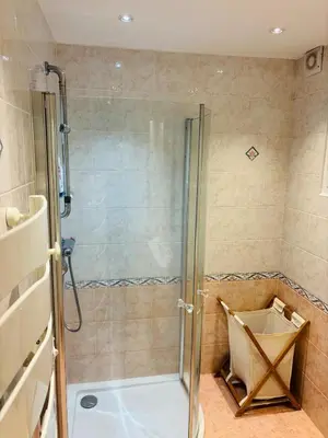 a shower with a glass door in a bathroom at Appartement au cœur de Cargèse in Cargèse