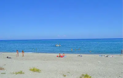 a group of people on a beach near the water at Villa Plage À Pieds in Moriani Plage