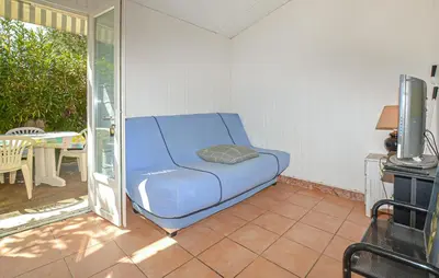 a blue couch in the corner of a room at Villa Plage À Pieds in Moriani Plage
