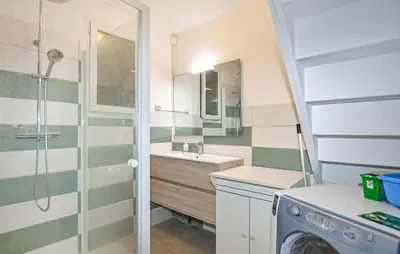 a bathroom with a sink and a washing machine at Villa Plage À Pieds in Moriani Plage