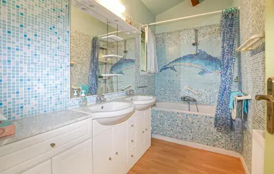 a blue tiled bathroom with two sinks and a tub at Villa Plage À Pieds in Moriani Plage