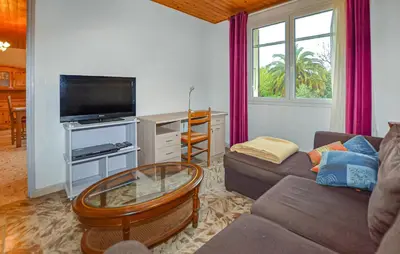 a living room with a couch and a flat screen tv at Villa Plage À Pieds in Moriani Plage