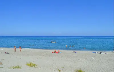 a group of people on a beach near the water at Villa Plage À Pieds in Moriani Plage