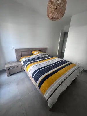 a bed with a striped blanket in a bedroom at Appartement T3 , 6 couchages in Ajaccio