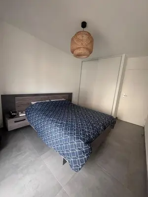 a bedroom with a bed with a blue comforter at Appartement T3 , 6 couchages in Ajaccio
