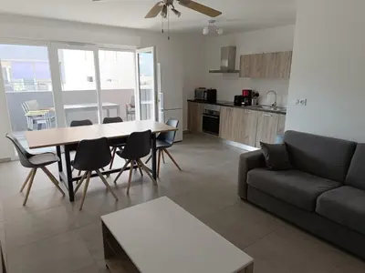 a living room with a couch and a table and chairs at Appartement T3 , 6 couchages in Ajaccio