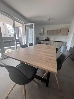 a wooden table and chairs in a living room at Appartement T3 , 6 couchages in Ajaccio