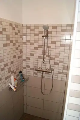 a shower with a hose in a tiled bathroom at SOLENZARA sea view in Sari Solenzara