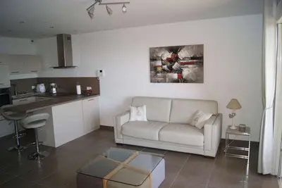 a living room with a couch and a kitchen at SOLENZARA sea view in Sari Solenzara