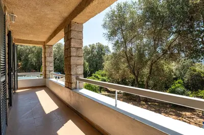 an outdoor balcony with a view of trees at Cozy Apartment with Pool in Olmeto