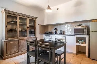 a kitchen with a table and chairs and a microwave at Cozy Apartment with Pool in Olmeto