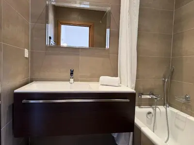 a bathroom with a sink and a mirror and a tub at T3 Cote Plage n 19 by Pinarello Villa Services in Pinarellu