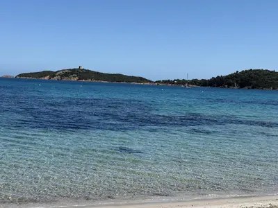 a large body of water with trees in the background at T3 Cote Plage n 19 by Pinarello Villa Services in Pinarellu
