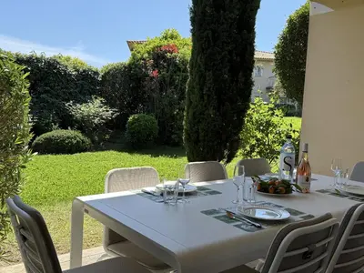 a white table with chairs and a bottle of wine at T3 Cote Plage n 19 by Pinarello Villa Services in Pinarellu
