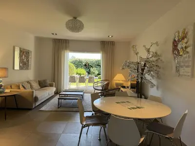 a living room with a table and chairs and a couch at T3 Cote Plage n 19 by Pinarello Villa Services in Pinarellu