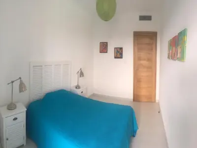a white room with a blue bed and a door at Marina di Fiori by Pinarello Villa Services in Furoli