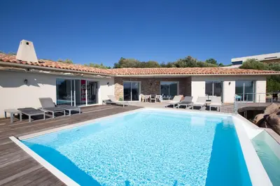 a villa with a swimming pool and a house at Padulaccia by Pinarello Villa Services in Pinarellu