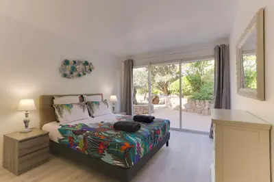 a bedroom with a bed and a large window at Padulaccia by Pinarello Villa Services in Pinarellu
