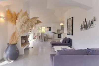 a living room with couches and a vase at Padulaccia by Pinarello Villa Services in Pinarellu
