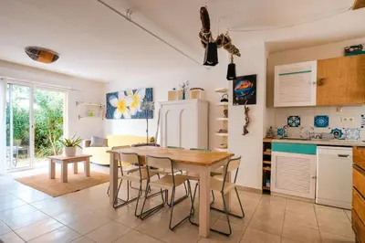 a kitchen with a table and chairs and a refrigerator at Villa ALOHA pool-beach 500m in Santa-Maria-Poggio