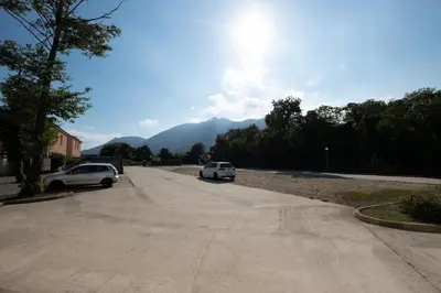 two cars parked in a parking lot with mountains in the background at Villa ALOHA pool-beach 500m in Santa-Maria-Poggio