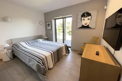 a bedroom with a bed and a table at Villa Alta Vista in Porto-Vecchio