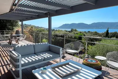 a patio with a couch and chairs on a deck at Villa Alta Vista in Porto-Vecchio