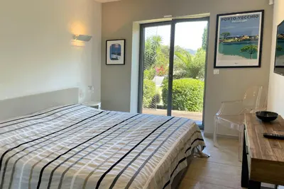 a bedroom with a bed and a desk and a window at Villa Alta Vista in Porto-Vecchio
