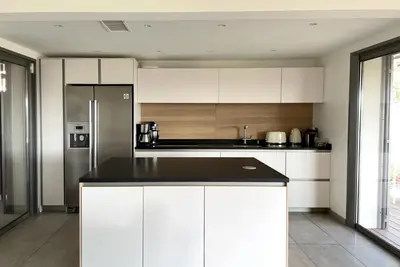 a kitchen with white cabinets and a refrigerator at Villa Alta Vista in Porto-Vecchio
