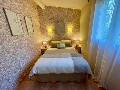 a bedroom with a bed with two lamps and a window at Camping Arutoli in Porto-Vecchio