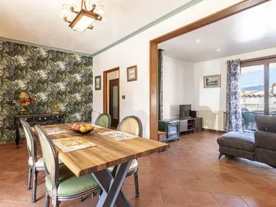 a dining room with a wooden table and chairs at Holiday Home Casa Féminiccia by Interhome in Ghisonaccia